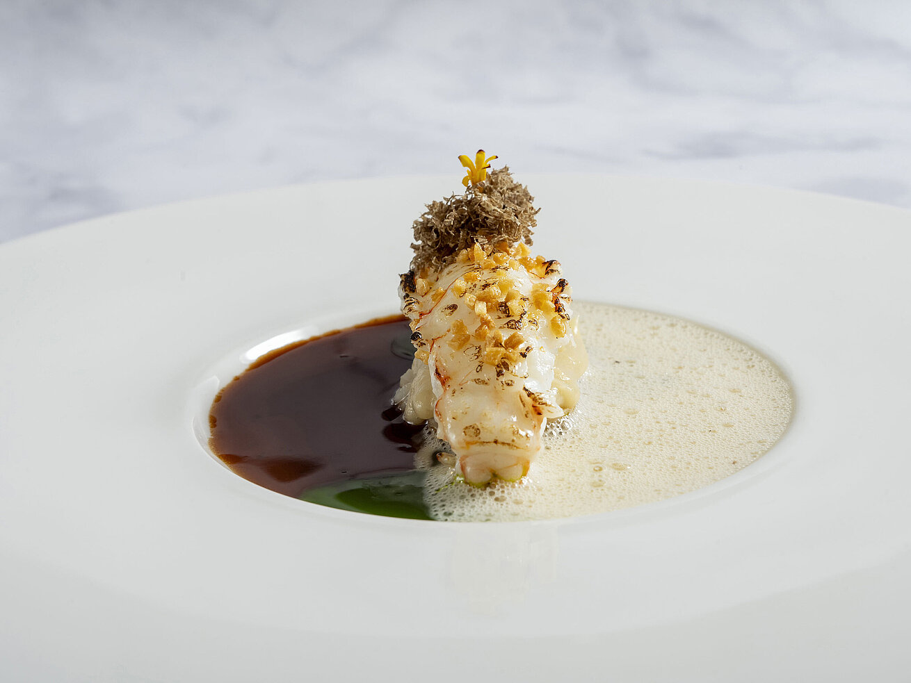 Langustino kunstvoll angerichtet mit feiner Sauce und eleganter Garnitur im Sternerestaurant Orangerie.