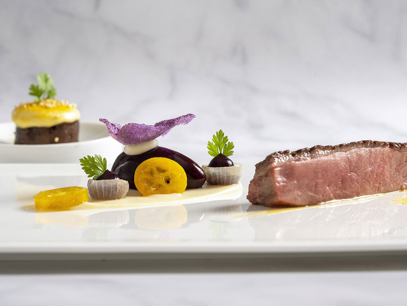 Wildente kunstvoll angerichtet mit feinen Beilagen und Sauce im Sternerestaurant Orangerie.